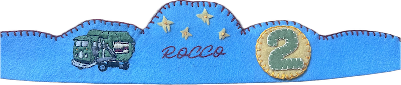 Sky-blue scalloped felt crown with an embroidered garbage truck, yellow stars, the name Rocco, and a number 2 patch.